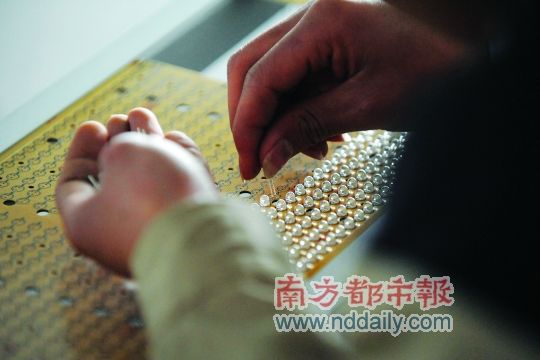 工人忙著安裝用于燈具發(fā)光的LED燈珠，這類工作處于LED燈具生產(chǎn)的最下游。資料圖